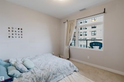Bedroom featuring neutral painted walls, carpeted flooring, a large window, and a roller blind - 