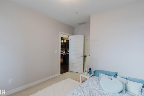 Interior room featuring light neutral wall paint, white trim, and carpet flooring - 510 5151 Windermere Boulevard, Edmonton, AB - Indoor Photo Showing Bedroom