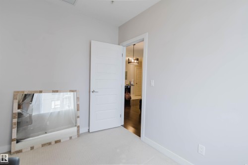 Light-toned wall finishes throughout - 510 5151 Windermere Boulevard, Edmonton, AB - Indoor Photo Showing Other Room