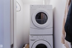 Dedicated laundry area featuring a stacked washer and dryer unit - 