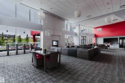 Spacious common area featuring full-height windows, a prominent fireplace, and an expansive wall-mounted entertainment area - 