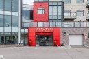 Contemporary multi-story building featuring a prominent red facade - 510 5151 Windermere Boulevard, Edmonton, AB  - Outdoor 