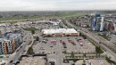 Aerial perspective showcasing an urban landscape with multiple multi-story residential buildings, a commercial center featuring a large grocery store, and extensive parking areas - 510 5151 Windermere Boulevard, Edmonton, AB  - Outdoor With View 