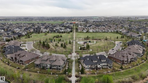 Residential area featuring a central green space, paved walking paths, and mature trees - 510 5151 Windermere Boulevard, Edmonton, AB - Outdoor With View