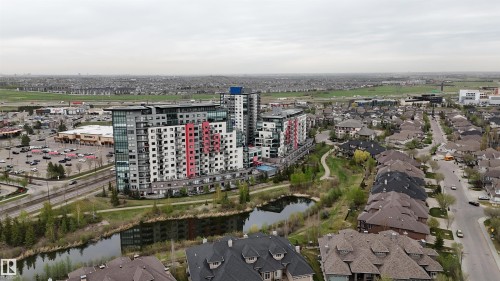 Modern multi-story buildings featuring varied facade treatments, including red and white accent panels - 510 5151 Windermere Boulevard, Edmonton, AB - Outdoor With View