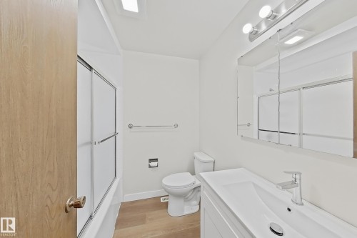 Bathroom featuring a white vanity with integrated sink, chrome faucet, and mirrored medicine cabinet - 1731 51 Street, Edmonton, AB - Indoor Photo Showing Bathroom