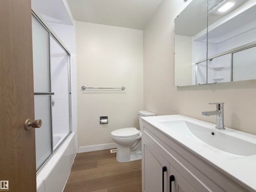 Bathroom featuring a white vanity with integrated sink, chrome faucet, and black hardware - 1731 51 Street, Edmonton, AB - Indoor Photo Showing Bathroom