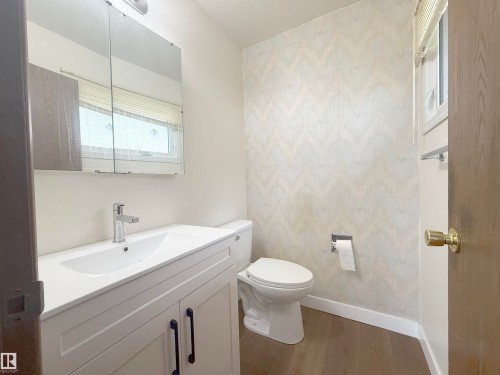 Bathroom featuring a white vanity with integrated sink, chrome faucet, and black cabinet pulls - 1731 51 Street, Edmonton, AB - Indoor Photo Showing Bathroom