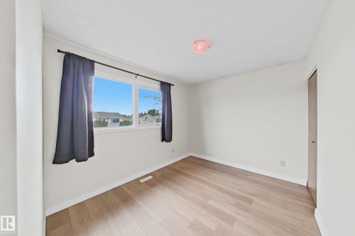 Bright interior room featuring a large window with blue sky and surrounding homes visible - 1731 51 Street, Edmonton, AB - Indoor Photo Showing Other Room