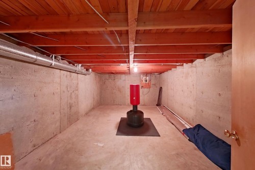 Unfinished basement space with concrete walls and floor, exposed wood ceiling joists, and visible ductwork - 1731 51 Street, Edmonton, AB - Indoor