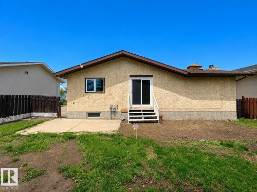 Rear exterior featuring textured stucco siding and a brown shingle roof - 1731 51 Street, Edmonton, AB - Outdoor