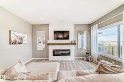 Living area featuring a shiplap fireplace surround with a wood mantel, an electric fireplace insert, and wood-finish flooring - 