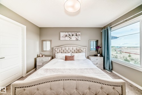 Light-colored walls featuring a large window, white trim, and a flush-mount ceiling light - 38 Prospect Place, Spruce Grove, AB - Indoor Photo Showing Bedroom