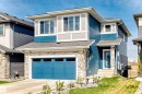 Contemporary two-story exterior featuring blue horizontal siding, stone facade accents, and a vibrant blue garage door - 38 Prospect Place, Spruce Grove, AB  - Outdoor With Facade 