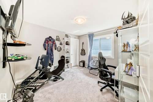 Carpeted room with a ceiling-mounted light fixture, a window with blinds and blue curtains, and light gray painted walls - 38 Prospect Place, Spruce Grove, AB - Indoor