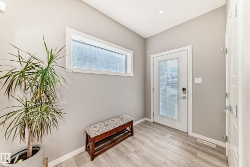 Entryway featuring wood-finish flooring, a white paneled door with frosted glass, and a transom window - 38 Prospect Place, Spruce Grove, AB - Indoor Photo Showing Other Room