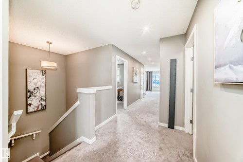 Expansive upper-level hallway featuring soft grey carpeting, recessed lighting, and a contemporary pendant light fixture - 38 Prospect Place, Spruce Grove, AB - Indoor Photo Showing Other Room