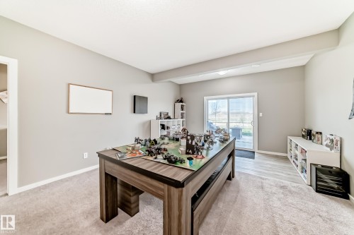 Spacious room featuring light gray walls, plush carpet flooring, a vaulted ceiling, and a sliding glass door providing exterior access - 38 Prospect Place, Spruce Grove, AB - Indoor Photo Showing Other Room