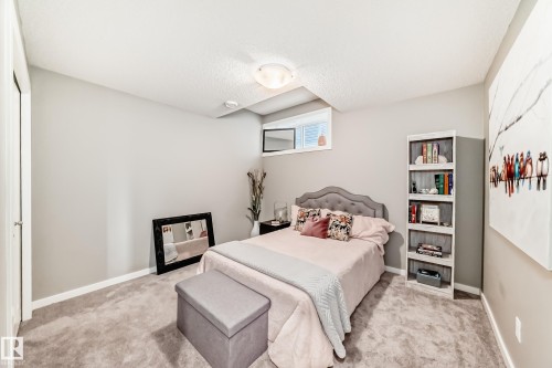Carpeted bedroom featuring light gray walls, white trim, a recessed window, and a built-in ceiling light fixture - 38 Prospect Place, Spruce Grove, AB - Indoor Photo Showing Bedroom