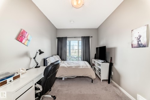 Carpeted room featuring a window with dark drapery, white baseboards, and a ceiling light fixture - 38 Prospect Place, Spruce Grove, AB - Indoor Photo Showing Bedroom