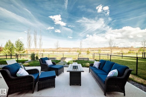 Expansive patio featuring a concrete surface, gravel borders, and a black chain-link fence - 38 Prospect Place, Spruce Grove, AB - Outdoor