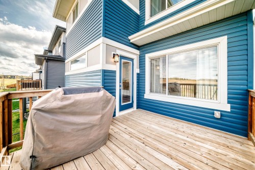 Spacious wood deck with a full-light exterior door, large sliding window, and blue horizontal siding - 38 Prospect Place, Spruce Grove, AB - Outdoor With Deck Patio Veranda With Exterior