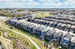 Townhome situated within a residential development, featuring a multi-level structure with a dark roof - 