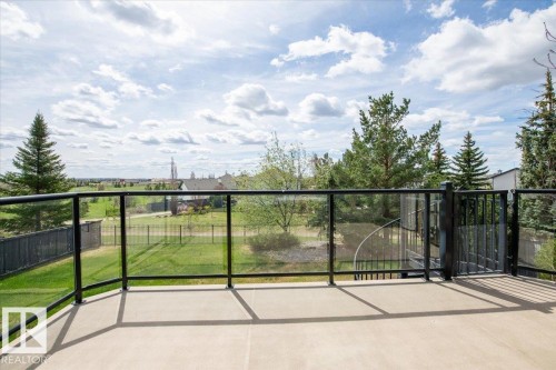 Concrete balcony with glass railing and black metal frame - 2413 Tegler Green, Edmonton, AB - Outdoor With View