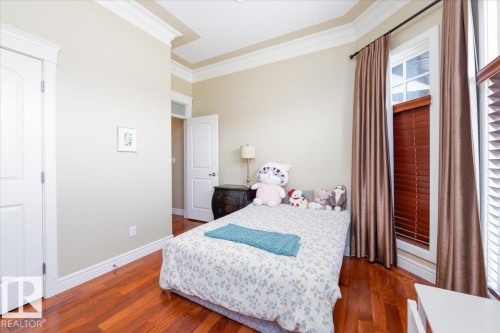 Hardwood flooring and crown molding accent this space - 2413 Tegler Green, Edmonton, AB - Indoor Photo Showing Bedroom