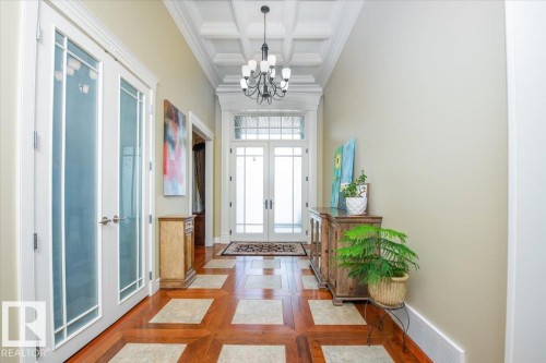 Foyer featuring a coffered ceiling, chandelier, and a wood-finish floor with square tile inlays - 2413 Tegler Green, Edmonton, AB - Indoor Photo Showing Other Room