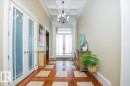 Foyer featuring a coffered ceiling, chandelier, and a wood-finish floor with square tile inlays - 2413 Tegler Green, Edmonton, AB  - Indoor Photo Showing Other Room 