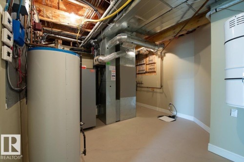 Utility room featuring a water heater, furnace, exposed ductwork, exposed ceiling joists, and painted concrete flooring - 2413 Tegler Green, Edmonton, AB - Indoor Photo Showing Basement