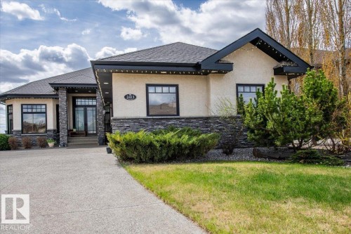 Stucco exterior featuring stacked stone accents and a prominent front entry with double glass doors - 2413 Tegler Green, Edmonton, AB - Outdoor