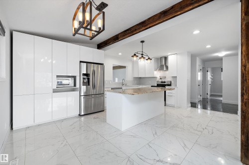 Modern kitchen featuring white cabinetry, stainless steel appliances, a center island with a stone countertop, and large format tile flooring - 11525 37A Avenue Nw, Edmonton, AB - Indoor Photo Showing Kitchen With Upgraded Kitchen