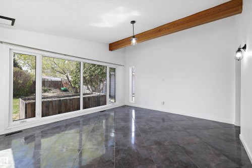 Expansive floor-to-ceiling windows overlooking a landscaped rear yard - 11525 37A Avenue Nw, Edmonton, AB - Indoor Photo Showing Other Room