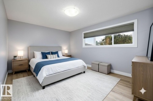 Bedroom featuring light wood-finish flooring, a contemporary ceiling light fixture, and a large horizontal window with blinds - 11525 37A Avenue Nw, Edmonton, AB - Indoor Photo Showing Bedroom