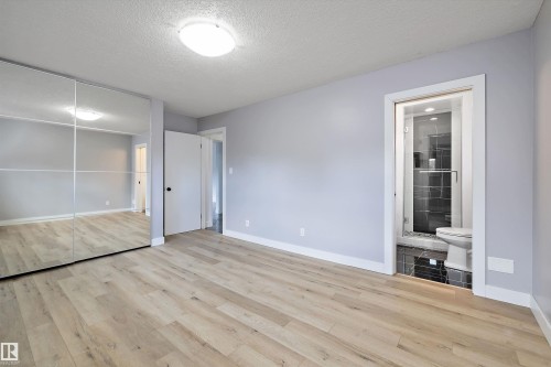 Light-toned wood-finish flooring complements the neutral wall color in this room featuring a mirrored closet - 11525 37A Avenue Nw, Edmonton, AB - Indoor Photo Showing Other Room