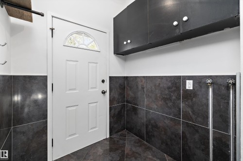 Utility area featuring dark tile flooring and coordinating dark tile wainscoting - 11525 37A Avenue Nw, Edmonton, AB - Indoor