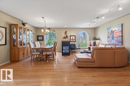 Spacious dining room is divided from family room/sitting area by a 3-sided gas fireplace - 49 52257 Rge Road 231, Rural Strathcona County, AB 