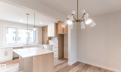 Open-concept living area with wood-finish flooring, a contemporary bronze chandelier, and recessed lighting - 