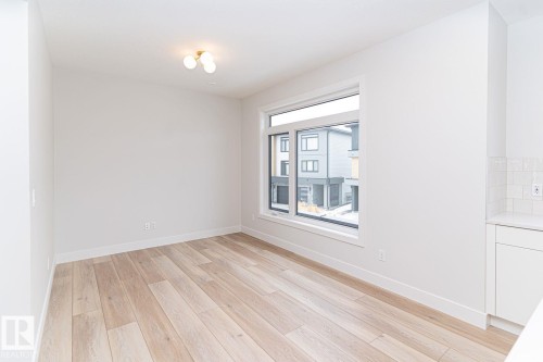 Bright room featuring light wood-finish flooring, white walls, and a large window - 53 7121 May Crescent, Edmonton, AB - Indoor Photo Showing Other Room