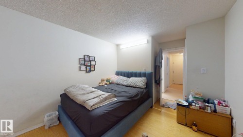 Room featuring light-toned wood-finish flooring, white walls, and a textured ceiling - 402 2624 Millwoods East Road E, Edmonton, AB - Indoor Photo Showing Bedroom