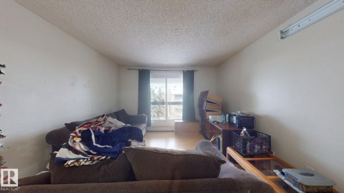Room featuring light-toned flooring, white walls, and a textured white ceiling - 402 2624 Millwoods East Road E, Edmonton, AB - Indoor