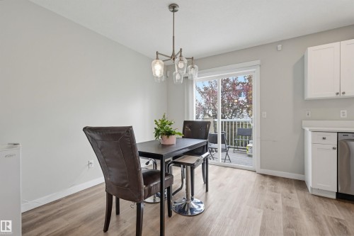 Dining area with wood-finish flooring and a contemporary chandelier - 11 3380 28A Avenue Nw, Edmonton, AB - Indoor Photo Showing Bathroom