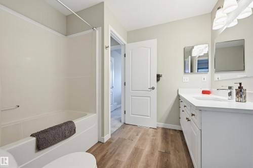Full bathroom featuring a single white vanity with a white countertop, chrome faucet, and integrated sink - 11 3380 28A Avenue Nw, Edmonton, AB - Indoor Photo Showing Other Room
