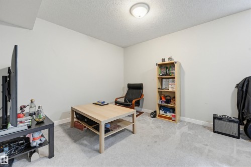 Neutral wall colors, textured ceiling, and light-toned carpet flooring - 11 3380 28A Avenue Nw, Edmonton, AB - Indoor Photo Showing Bedroom