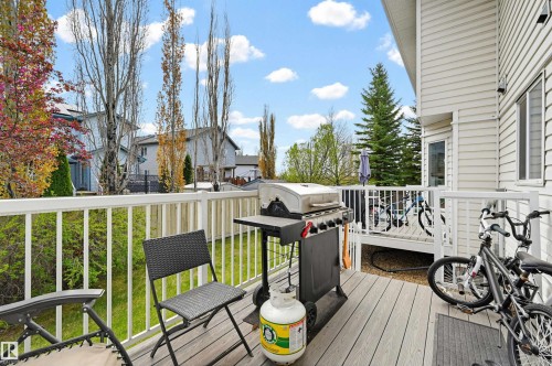 Composite wood deck with white railing, featuring siding exterior and visible landscaping - 11 3380 28A Avenue Nw, Edmonton, AB - Outdoor With View