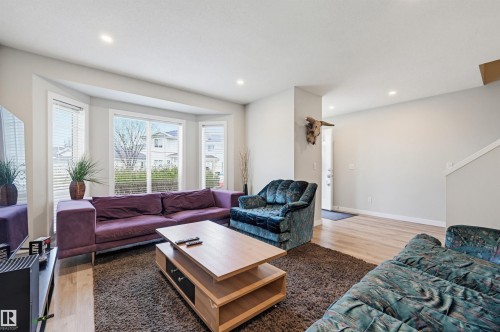 Open-concept living space featuring wood-finish flooring, recessed lighting, and a bay window - 11 3380 28A Avenue Nw, Edmonton, AB - Indoor Photo Showing Living Room