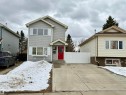 The property features a light grey exterior with white window shutters and a prominent red front door - 18425 95A Avenue, Edmonton, AB  - Outdoor With Facade 