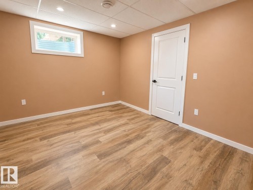 Contemporary bathroom featuring a walk-in shower with tile surround, integrated shelving, and a rain shower head - 4418 45 Avenue, Bonnyville Town, AB 